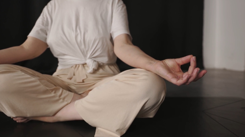 A person sits cross-legged in meditation, combining yoga with medical treatment for autoimmune care