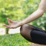 Person practicing yoga for migraine relief outdoors